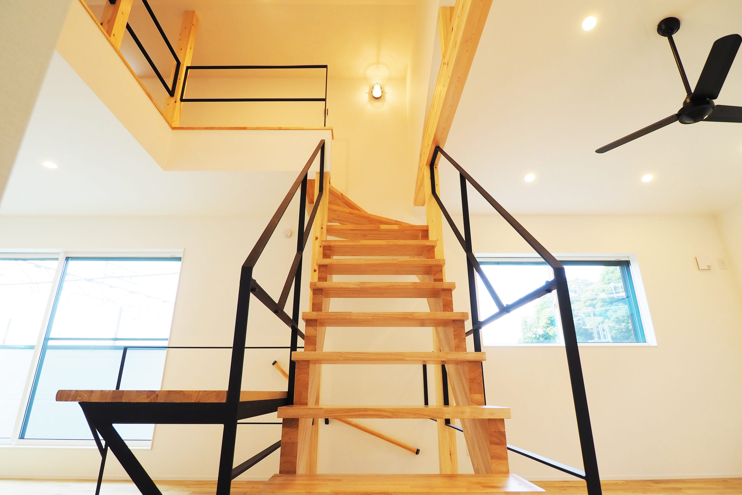 ブラックアイアン手すりと、木製ストリップ階段がカッコいい家